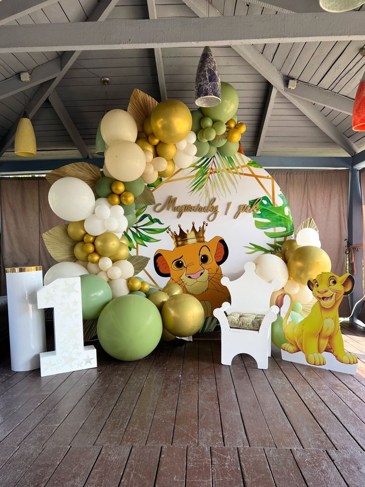 a room filled with balloons and animals on the floor next to a sign that says lion king