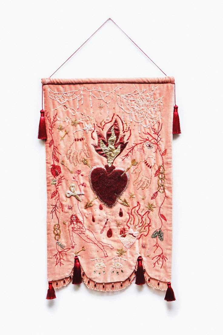 a pink wall hanging with a heart on it