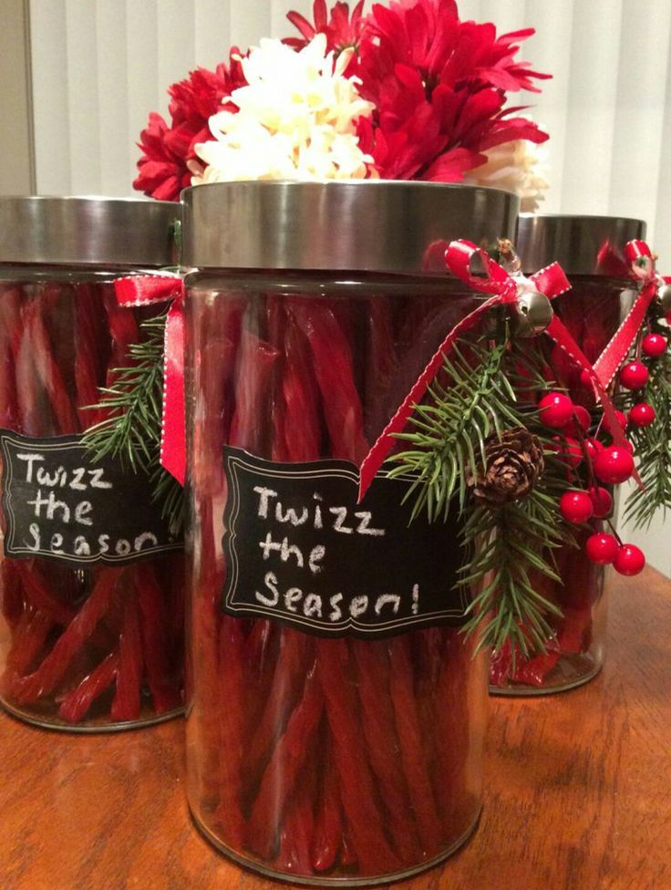 three jars filled with red hot dogs sitting on top of a wooden table