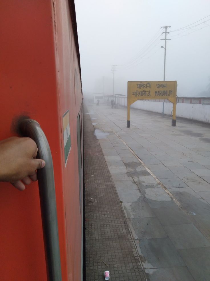 a person's hand is on the handle of a red door with a yellow sign