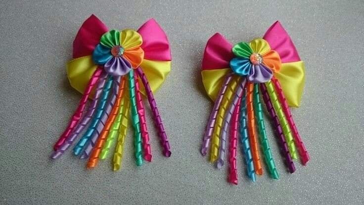 two colorful hair clips with bows on them