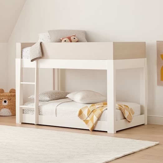 a white bunk bed sitting on top of a wooden floor next to a stuffed animal