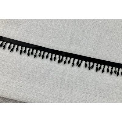 a black and white curtain with fringes on the edge is seen in this image