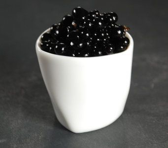 a white bowl filled with blackberries on top of a table