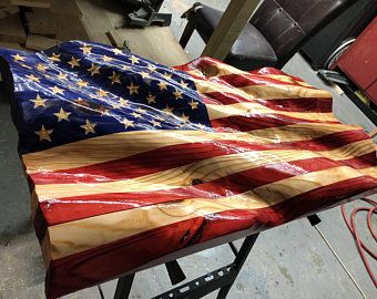 an american flag made out of wood sitting on top of a workbench in a shop