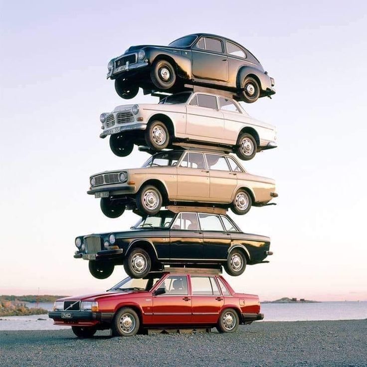 four cars stacked on top of each other in the shape of a tower with their wheels down