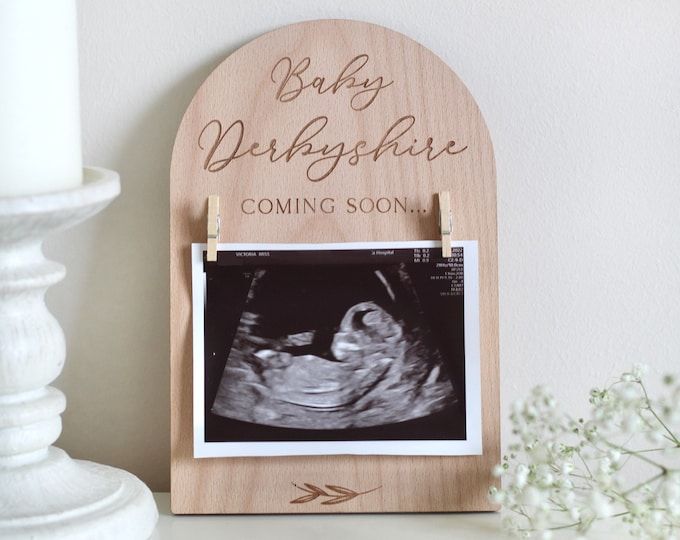 a wooden plaque with an x - ray image and baby's birth announcement on it