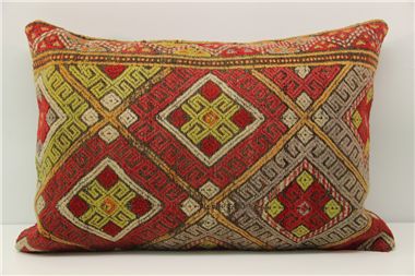 a red and yellow decorative pillow sitting on top of a white table