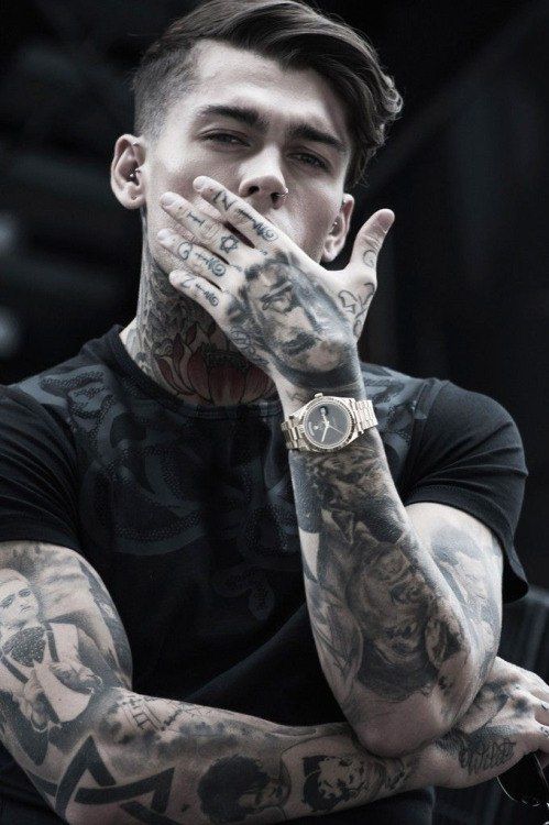 a man with tattoos on his arms and hands