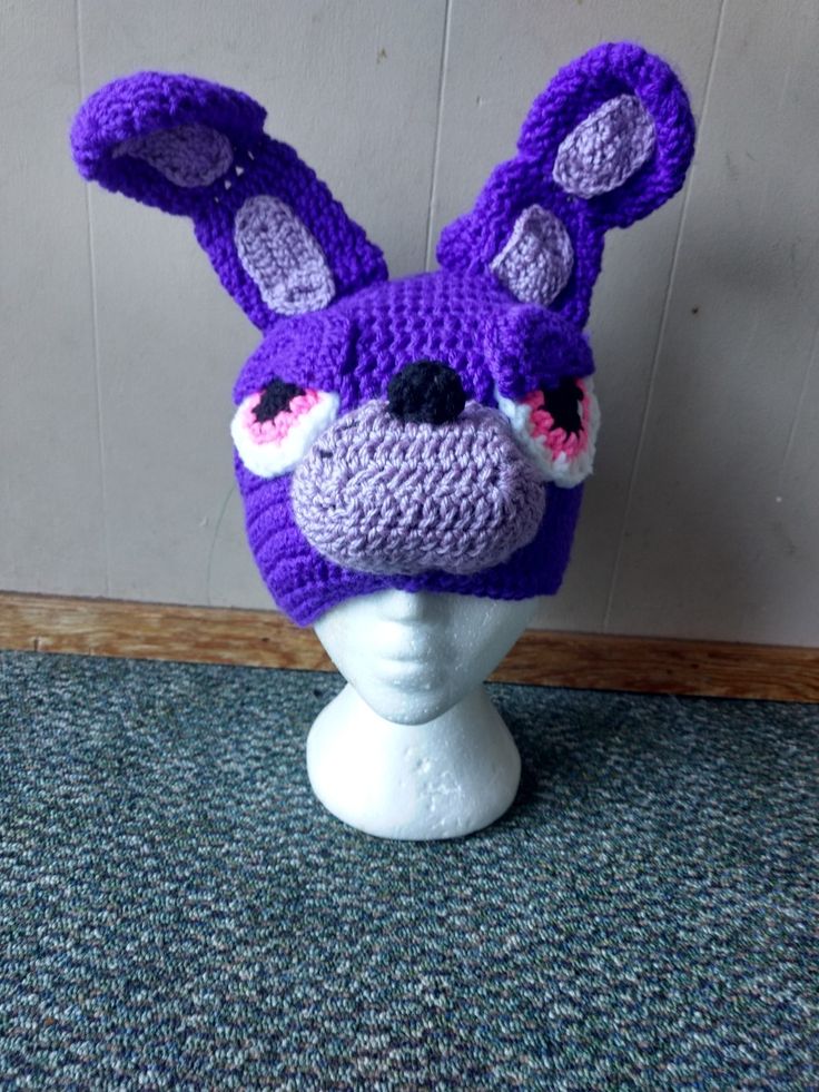 a crocheted hat with ears on top of a mannequin head