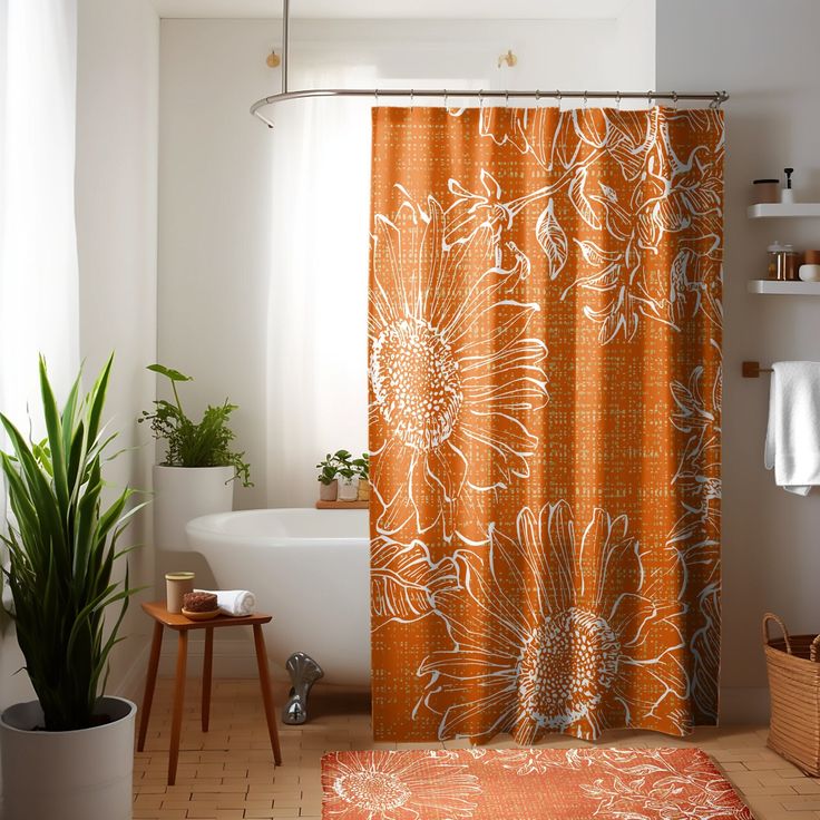 an orange shower curtain in a bathroom next to a bathtub and sink with a potted plant