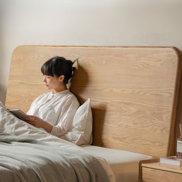 a woman sitting in bed reading a book