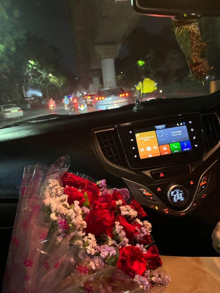 flowers are sitting in the passenger seat of a car with an electronic screen on it