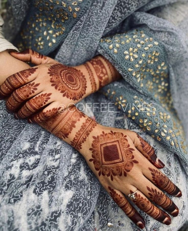 a woman's hands with hennap on her hand and the bottom half of her arm