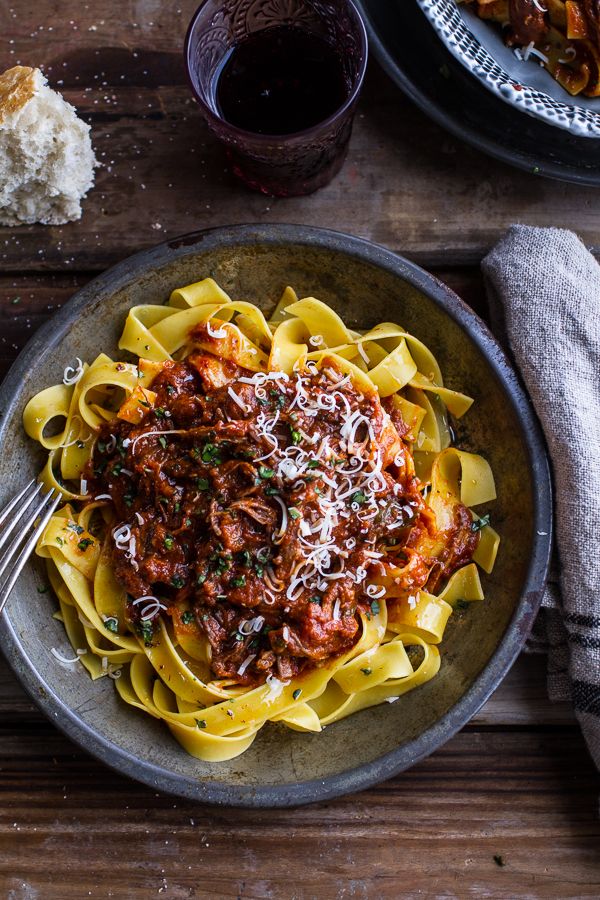 pasta with meat sauce and parmesan cheese in a bowl on a wooden table