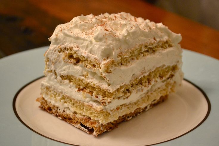 a piece of cake on a plate with white frosting and brown trim around the edges