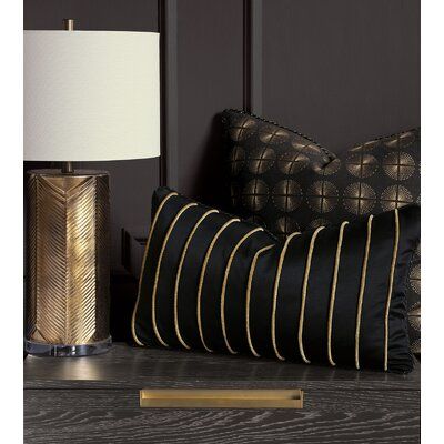 a black and gold striped pillow next to a lamp