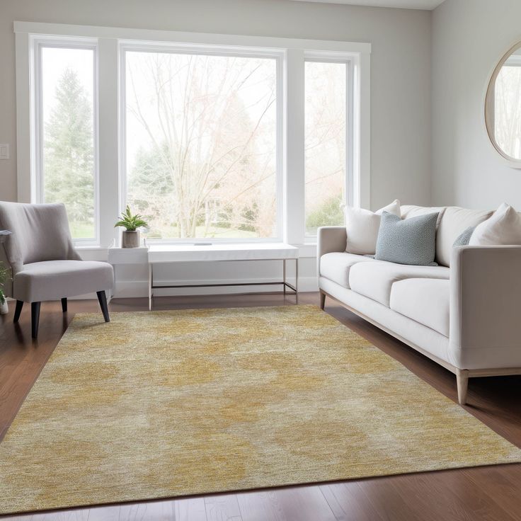 a living room with white couches and large windows in the corner, along with a yellow area rug