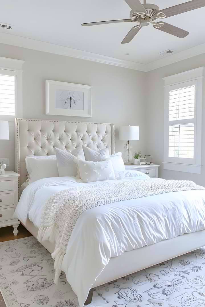 a white bedroom with a large bed and ceiling fan