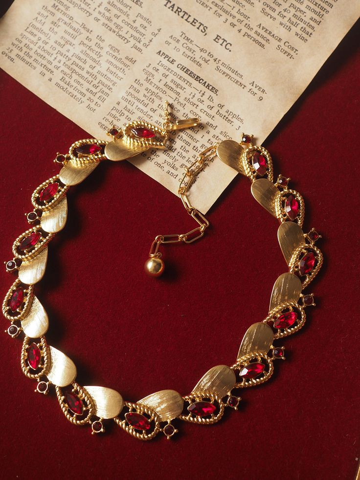 levate your style with the Ruby-Red Elegance Necklace, a stunning accessory designed to capture attention. This exquisite piece features a striking combination of ruby-red stones and golden elements, elegantly arranged in a unique and contemporary pattern. Perfect for adding a touch of sophistication and luxury to any outfit, whether for a special occasion or daily wear. Details: Material: Brass with gold plating Length: 33 cm with an additional 9 cm extension chain Weight: Approximately 46 g Care Instructions: To maintain the beauty and longevity of your necklace, avoid direct contact with water, perfumes, or chemicals. Red Stone, Ruby Red, Vintage Necklace, Accessories Design, Ruby, Chain, Stone, Red, Gold