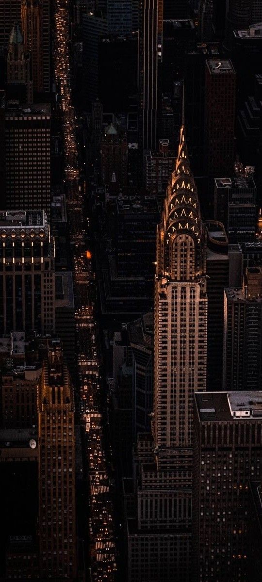 an aerial view of skyscrapers at night in new york city, with the lights on