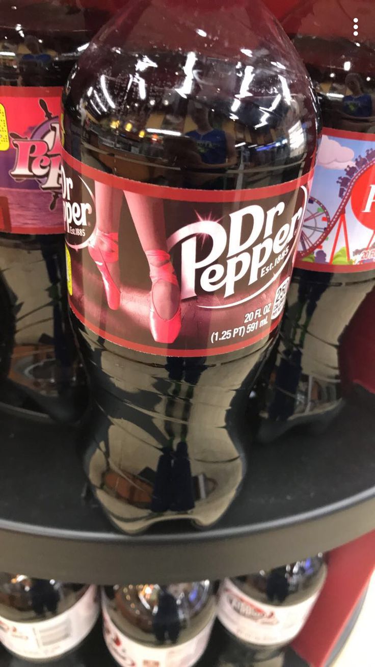 several bottles of soda are stacked on a shelf