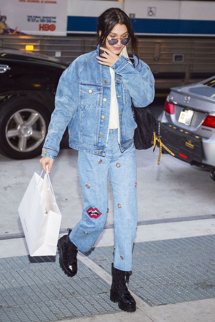 a woman walking down the street while talking on her cell phone and holding shopping bags