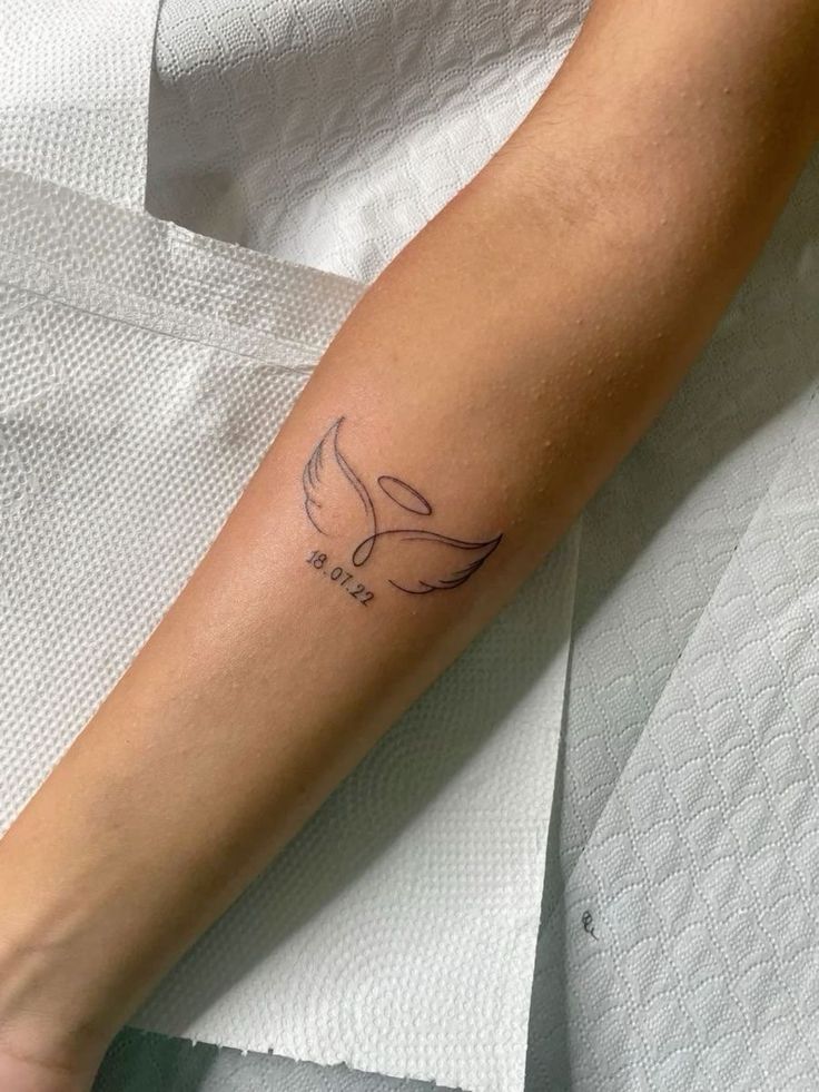 a woman's arm with a tattoo on it that has a bird in the middle