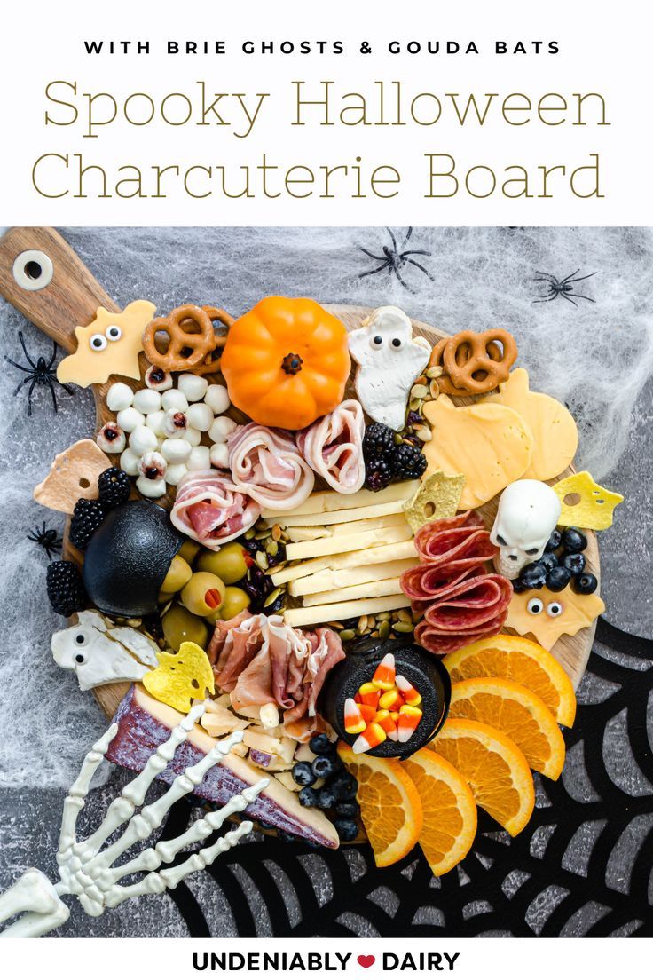 spooky halloween charcuterie board with oranges, blackberries and candy