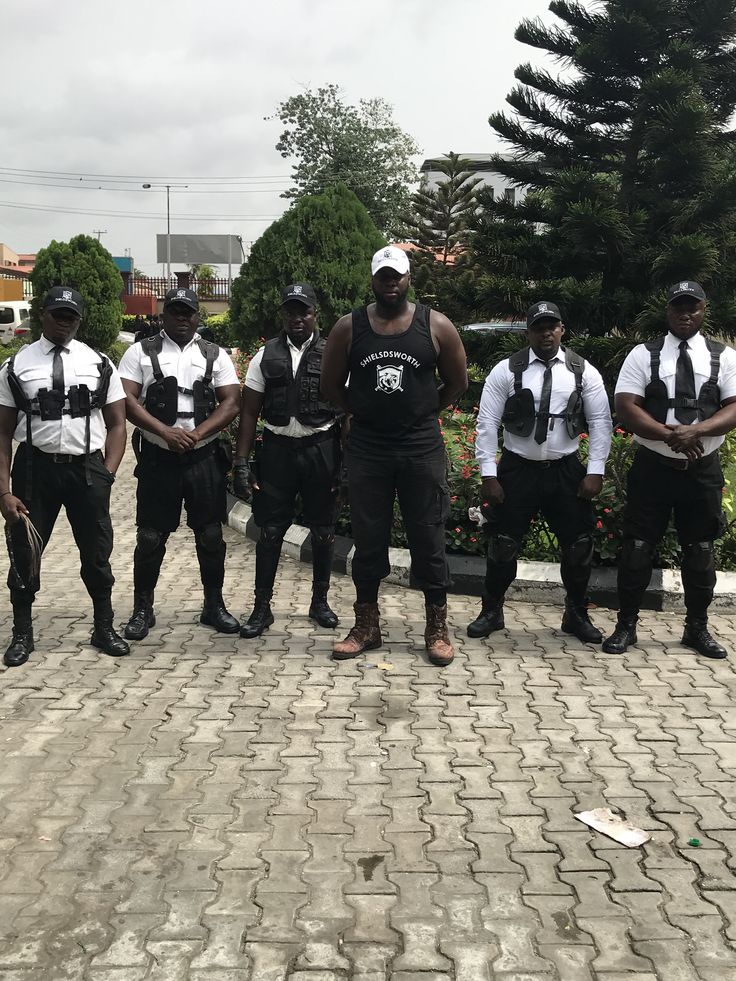 five men in police uniforms standing on a brick road