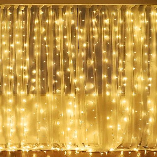 a living room filled with lots of lights next to a window covered in sheer curtains