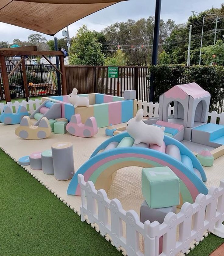 an inflatable play area is set up on artificial grass and surrounded by wooden fences