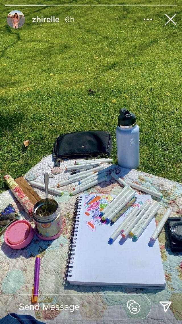 an open notebook sitting on top of a table covered in art supplies