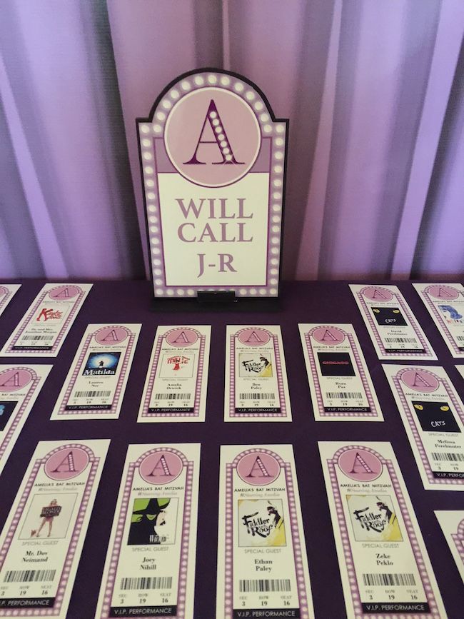 a purple table topped with lots of cards next to a sign that says will call j r