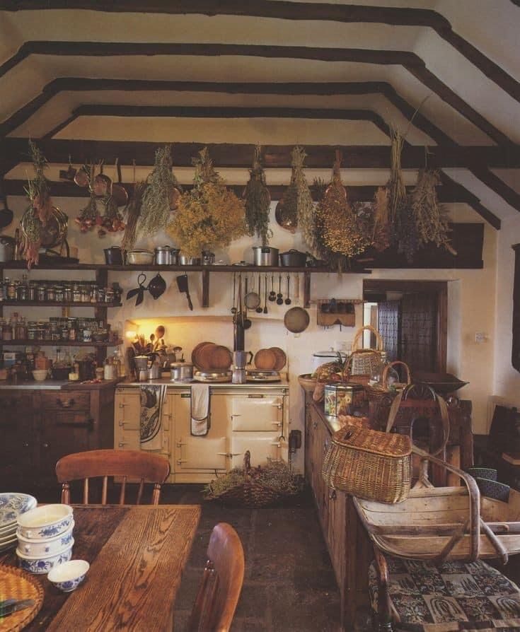 an old fashioned kitchen with many pots and pans hanging from the ceiling