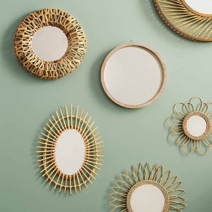 four mirrors are arranged next to each other on a green wall, with gold accents