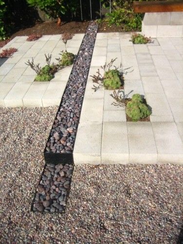 a garden with gravel, rocks and plants in it