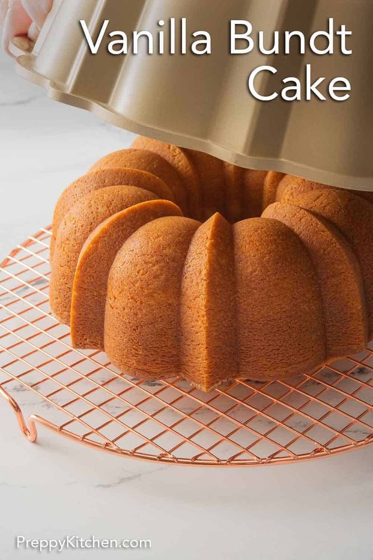 a bundt cake sitting on top of a cooling rack with the words vanilla bundt cake above it