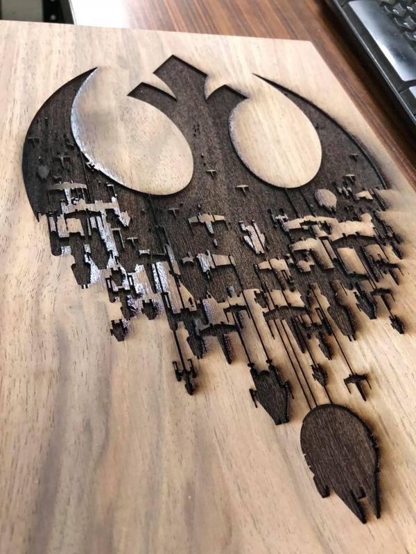 a wooden cutting board with star wars symbols on it