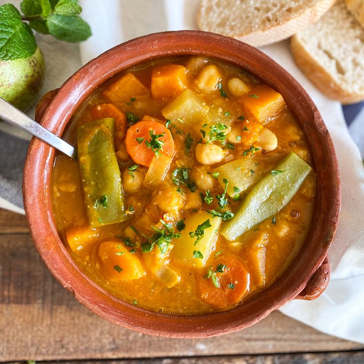 a bowl filled with soup next to some bread