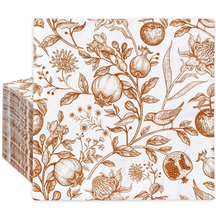 an orange and white paper napkin with floral design on the front, featuring pomegranates and leaves