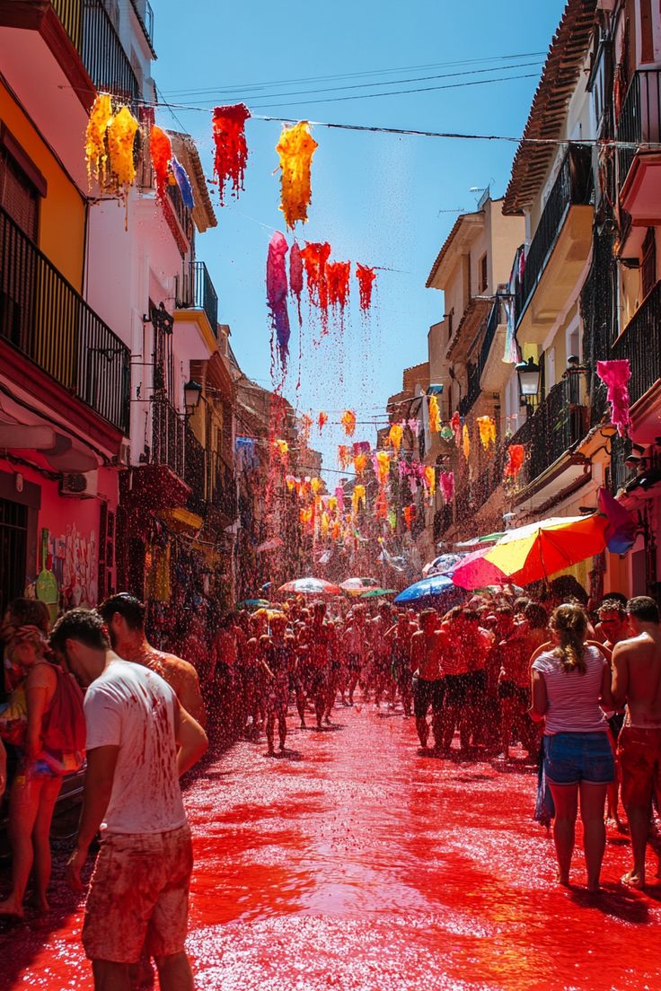 the people are playing with colored water in the street as they walk down the street