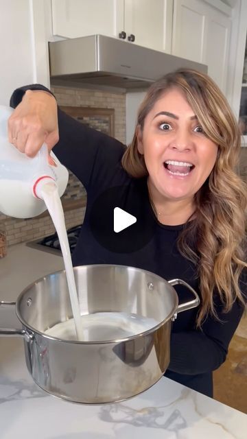 a woman pouring milk into a pot on the kitchen counter