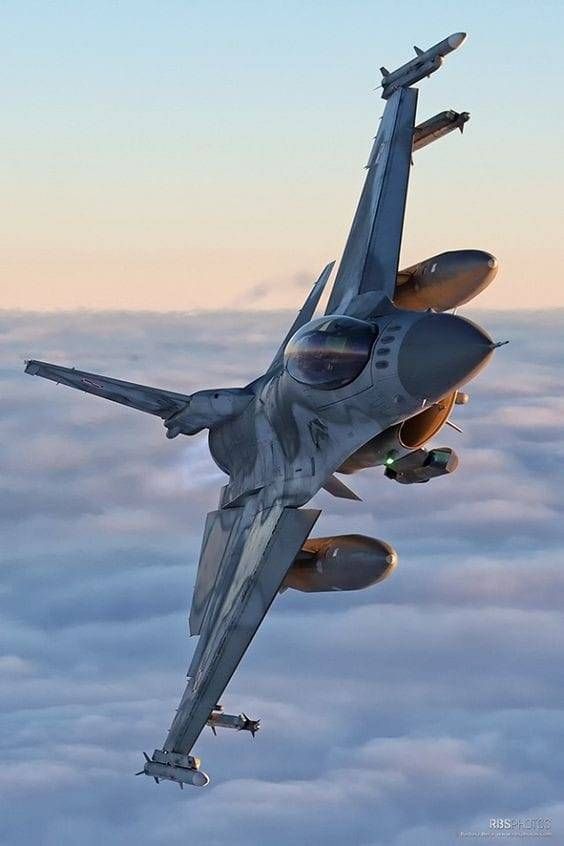 a fighter jet flying through the sky above clouds