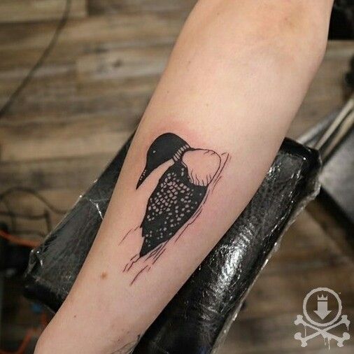 a black and white bird tattoo on the right arm, with dots in it's body