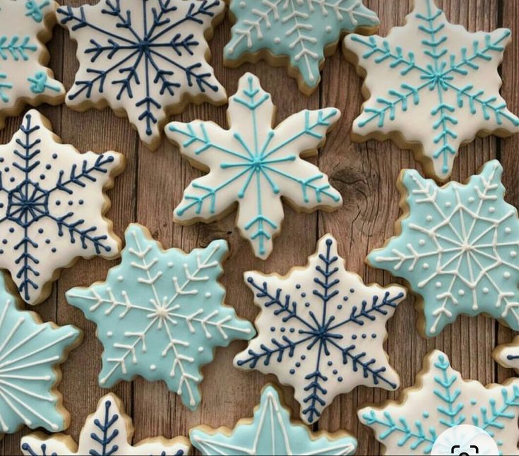 snowflake cookies are arranged on a wooden table with the words sweet creations by kaleen