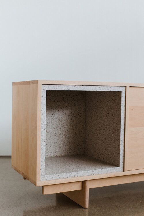 a wooden cabinet with two open compartments on the front and one closed drawer on the back