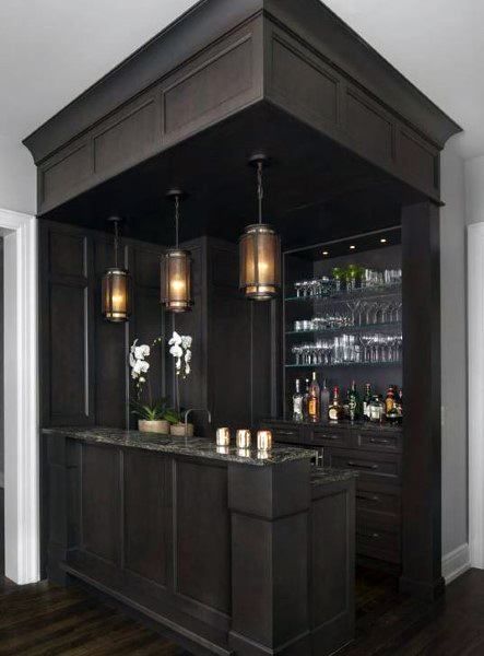 a kitchen with dark wood cabinets and marble counter tops, along with an island in the middle