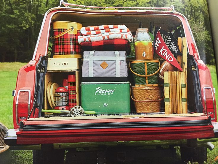 the back end of a red truck filled with luggage