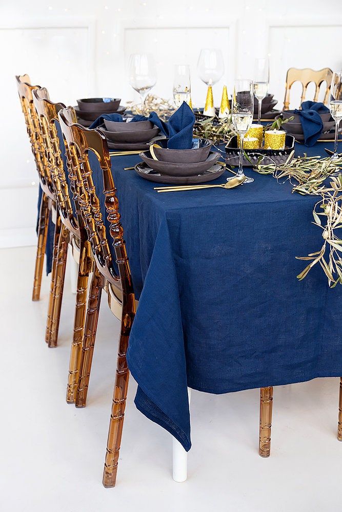 the table is set with blue linens and place settings